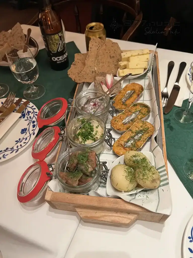 Plat traditionnel suédois dans le restaurant Kometen avec plusieurs bocaux de poisson, assiette de fromage et pommes de terre