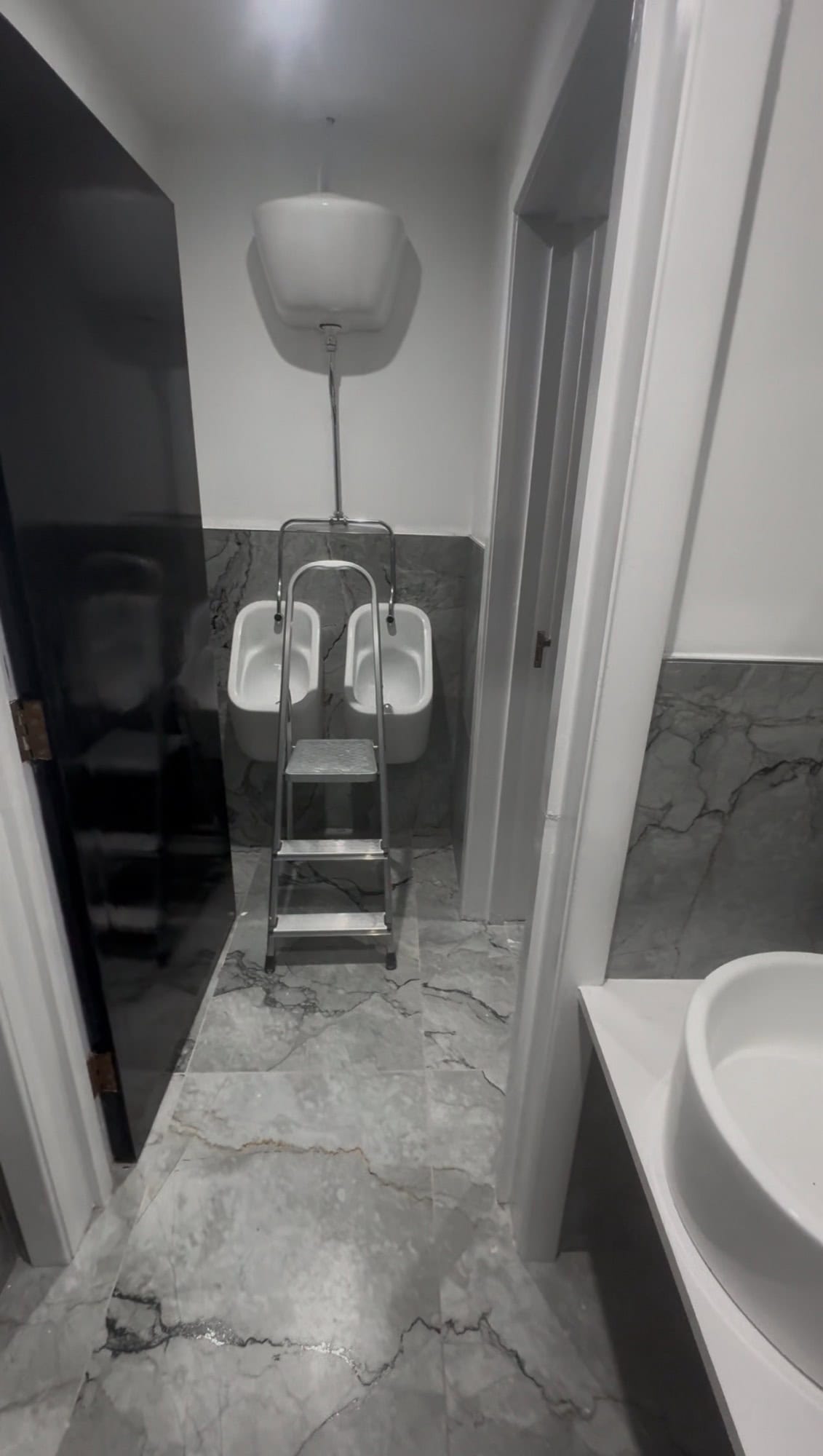 urinals installed in toilet in Glasgow by qualified plumber, phot shows toilet system and urinals being tested.