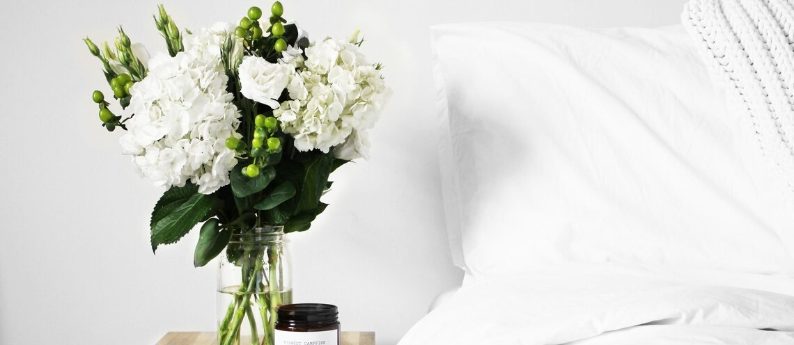 Flowers next to white bed