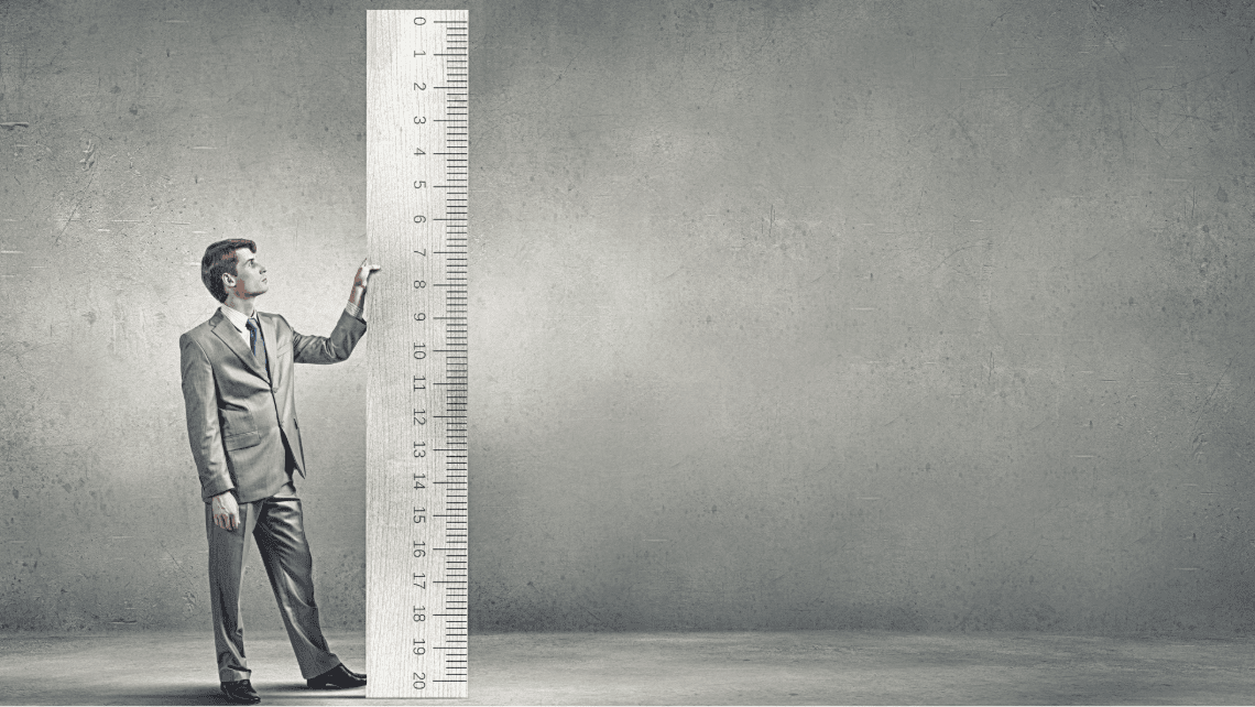 A man next to a huge ruler
