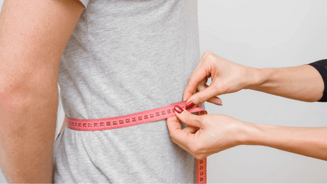 a man having his waist measured