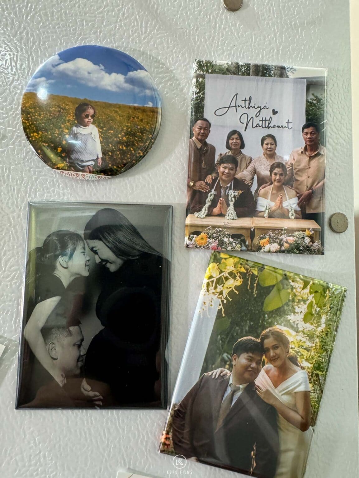 Photo fridge magnets from a magnet photo booth on a fridge door