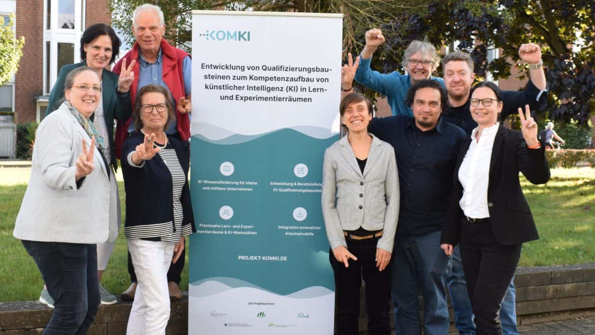 Gruppe von Fachleuten bei ITB Karlsruhe mit Banner im Freien.
