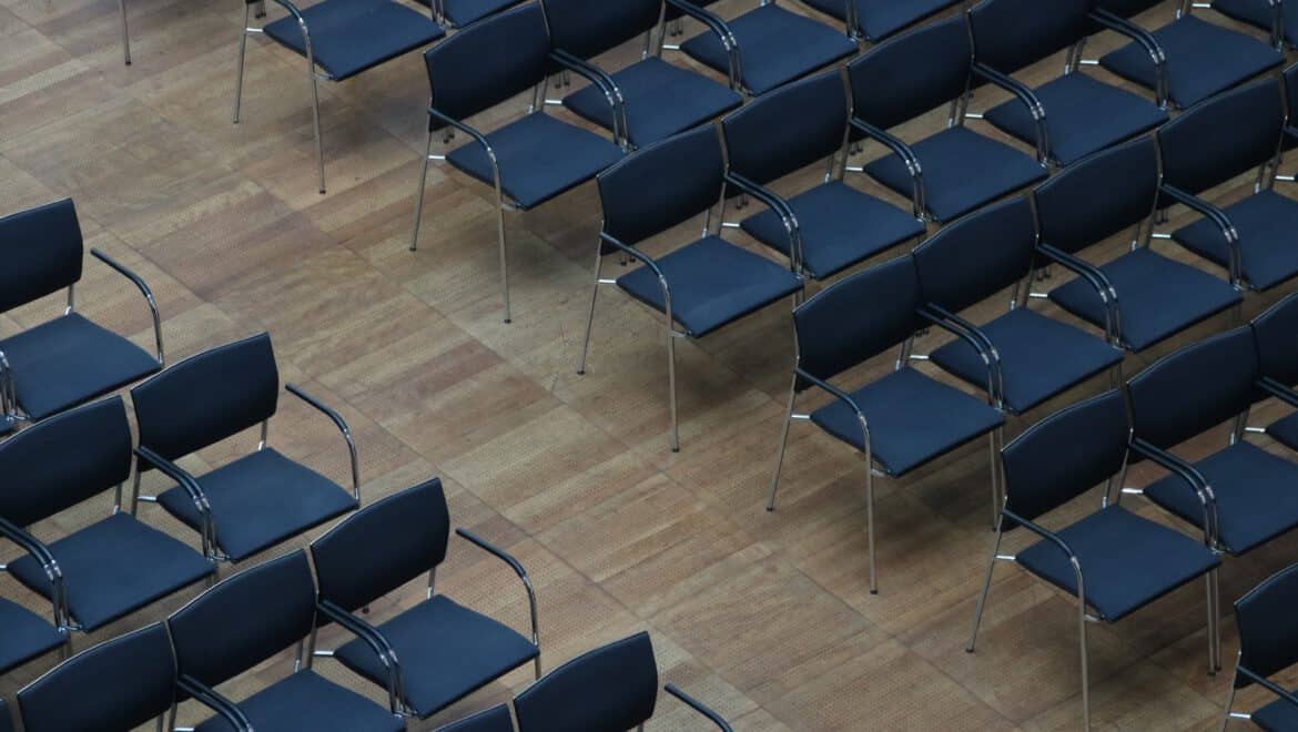 Leere Sitzreihen bei ITB Karlsruhe, Konferenzraum mit blauen Stühlen.