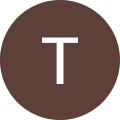 A white capital letter "T" centered on a solid brown circular background.