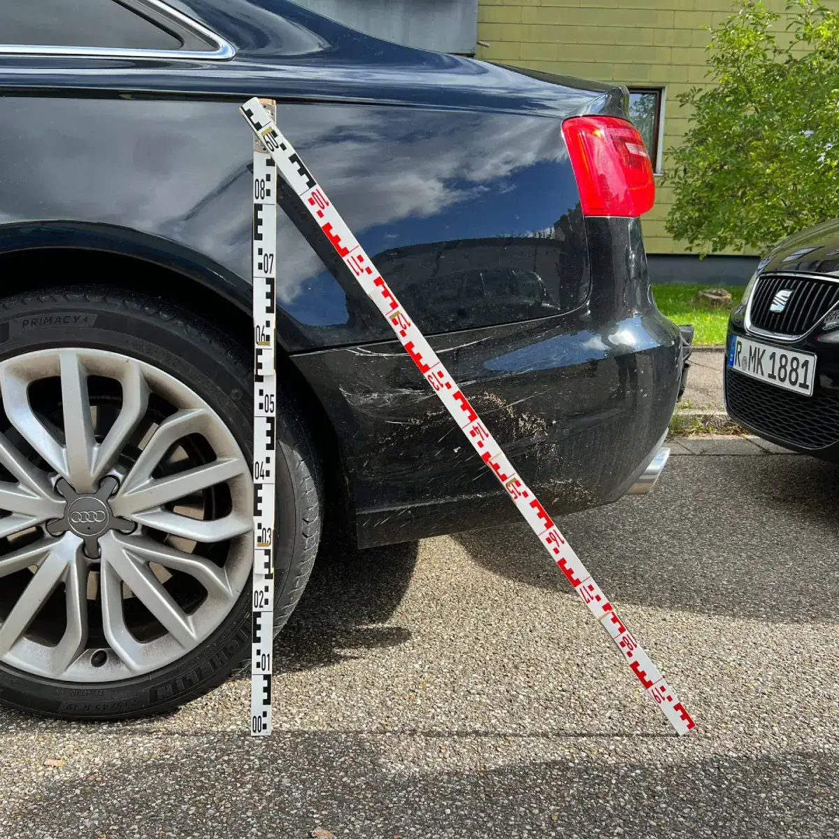 Schadensaufnahme an einem Auto mit Maßstab für ein Unfallgutachten in Regensburg