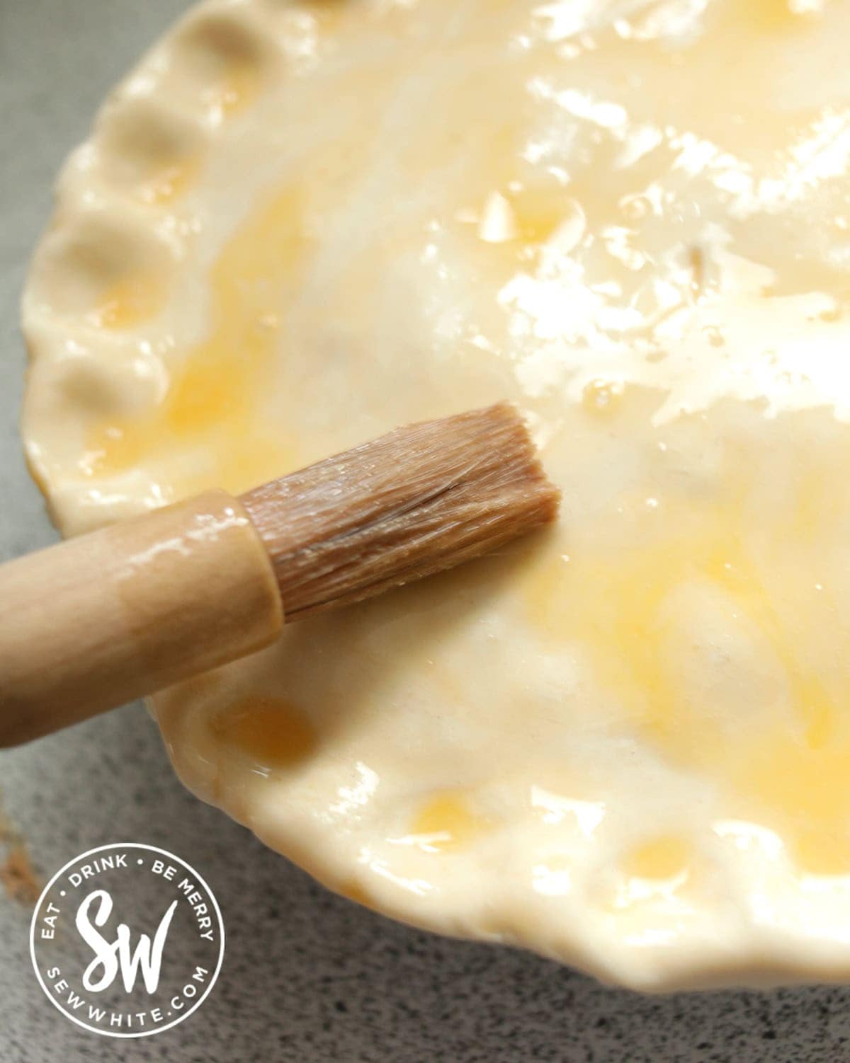 brushing the puff pastry pie lid with a beaten egg.