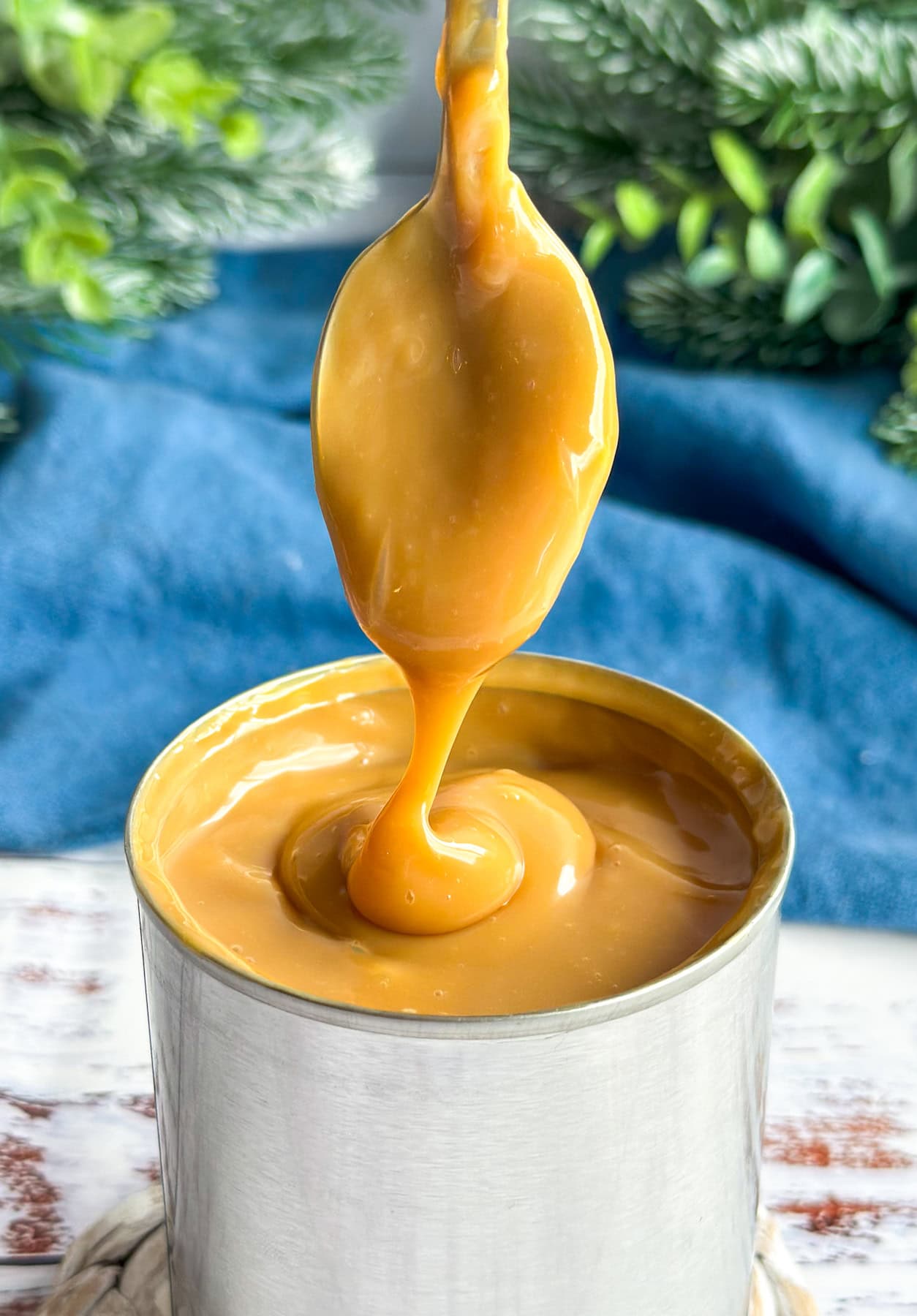 Can of sweetened condensed milk turned into Dulce Le Leche drizzled off the end of a teaspoon