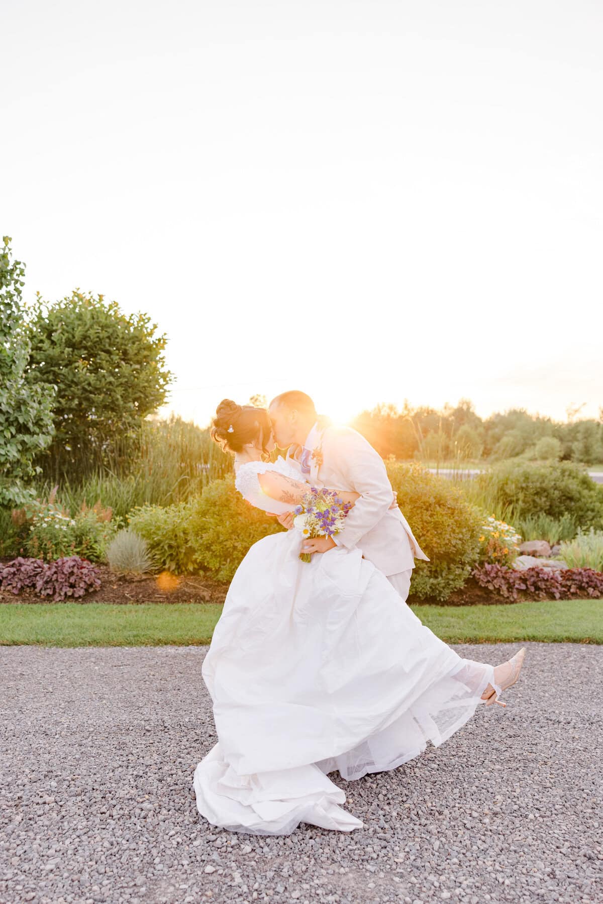 Sophie and Josh share a sun-flare kiss during golden hour at Aquatopia
