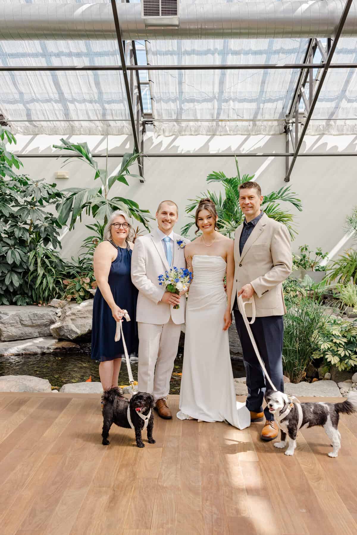Sophie and Josh pose with their two dogs at their Aquatopia wedding