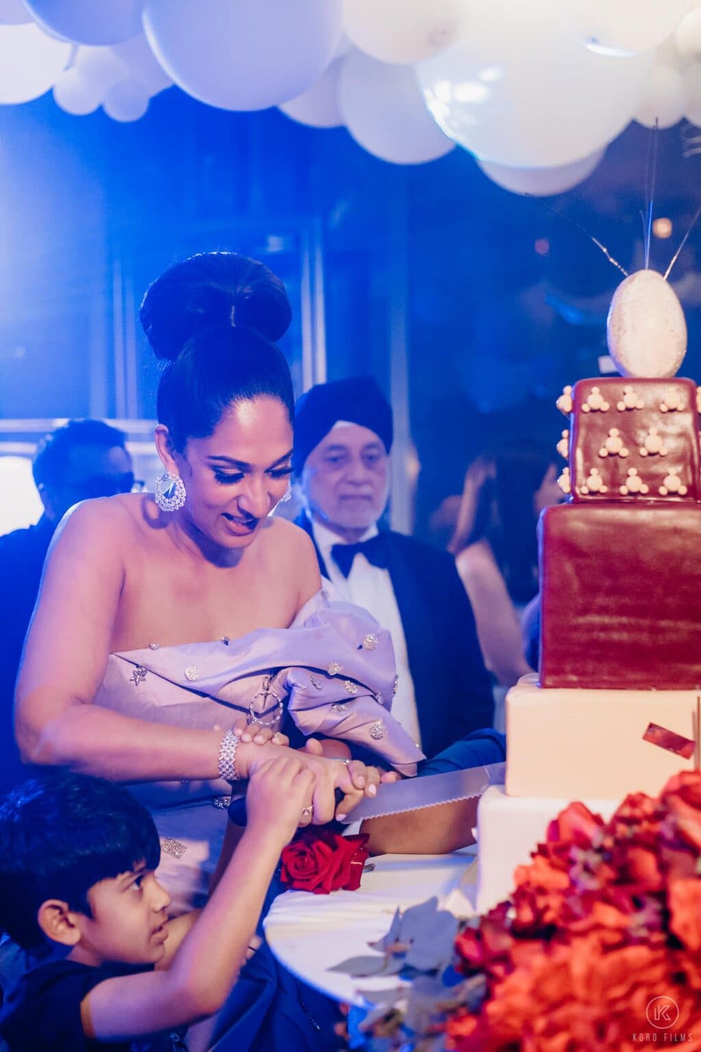 Radhika beside her tiered birthday cake at her 40th birthday dinner