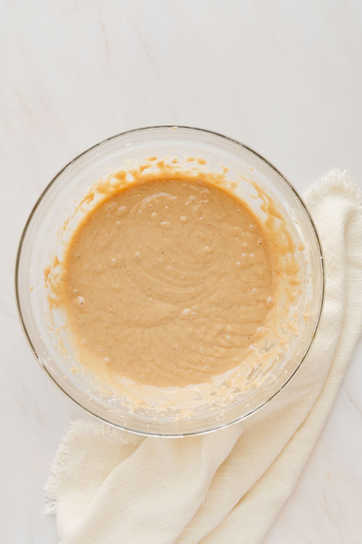 Chai cupcake batter in a large glass mixing bowl.