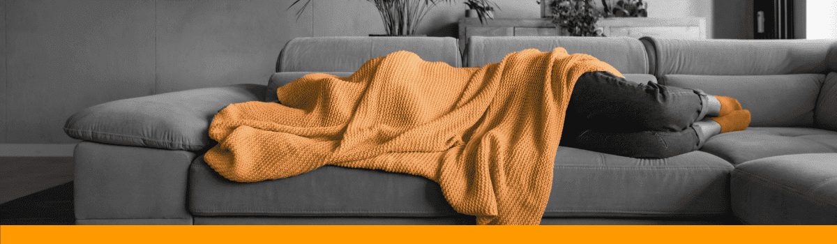 Person sleeping under blanket on sofa
