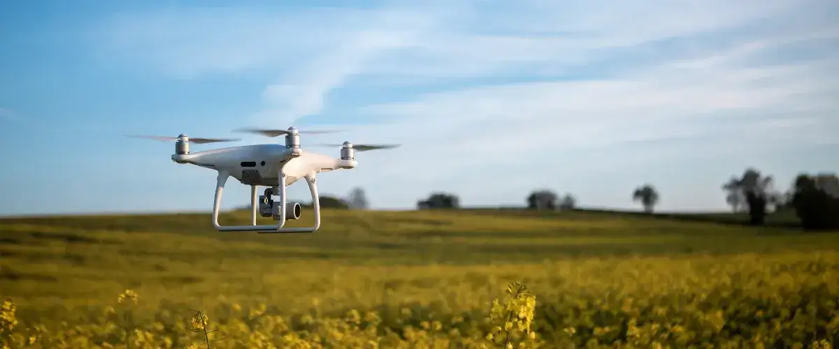A drone scanning over crop fields, capturing data to improve agricultural efficiency.