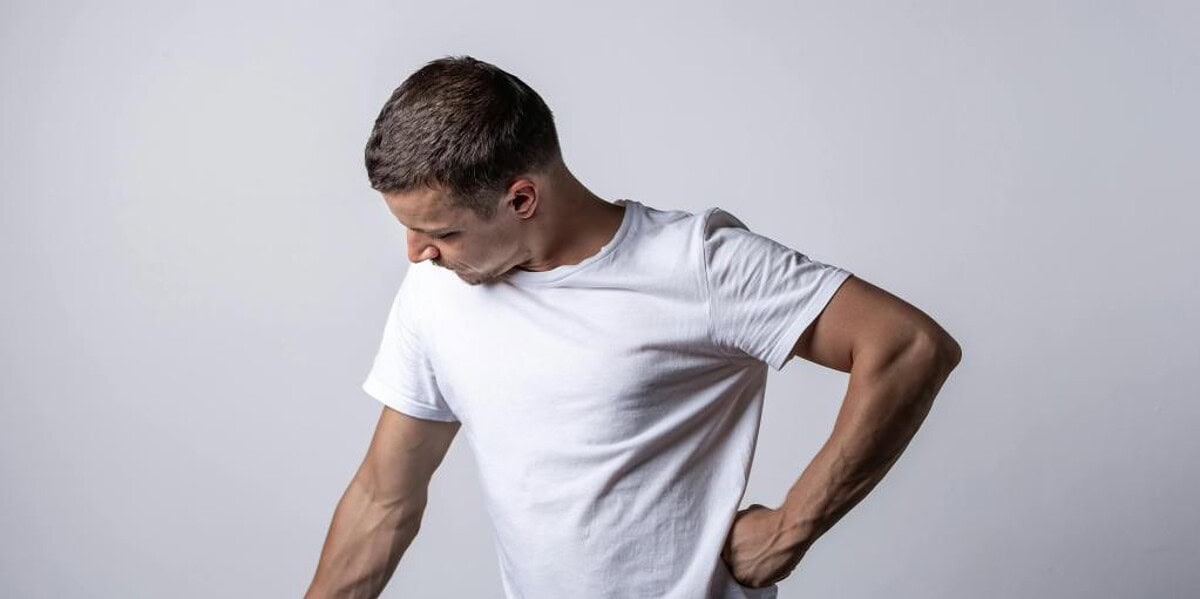 Man sitting at home in discomfort from a pilonidal cyst