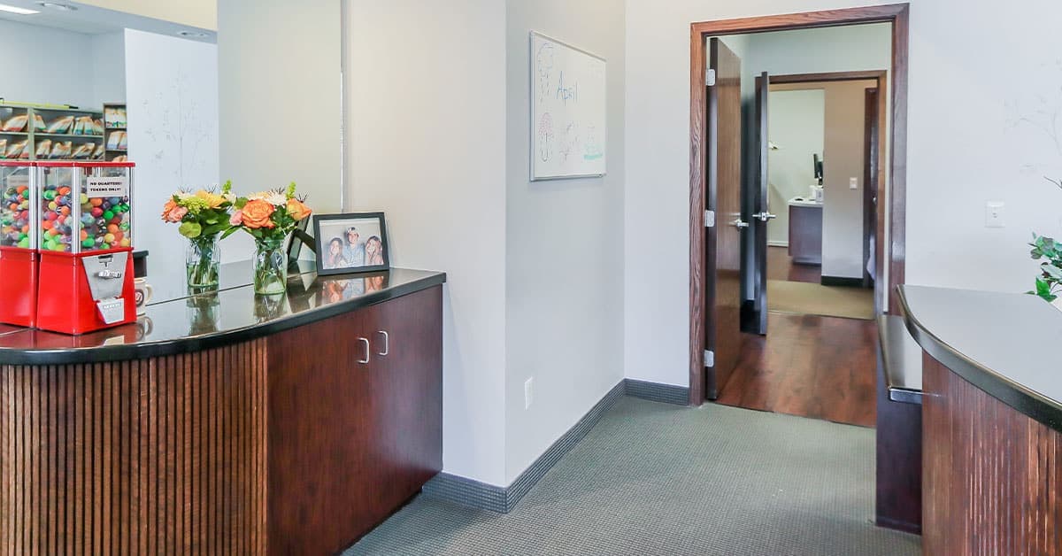 Dental office interior with reception desk and hallway.
