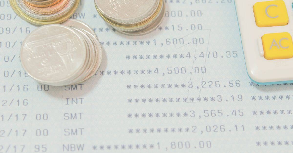 貯金通帳とお金と計算機のイメージ写真