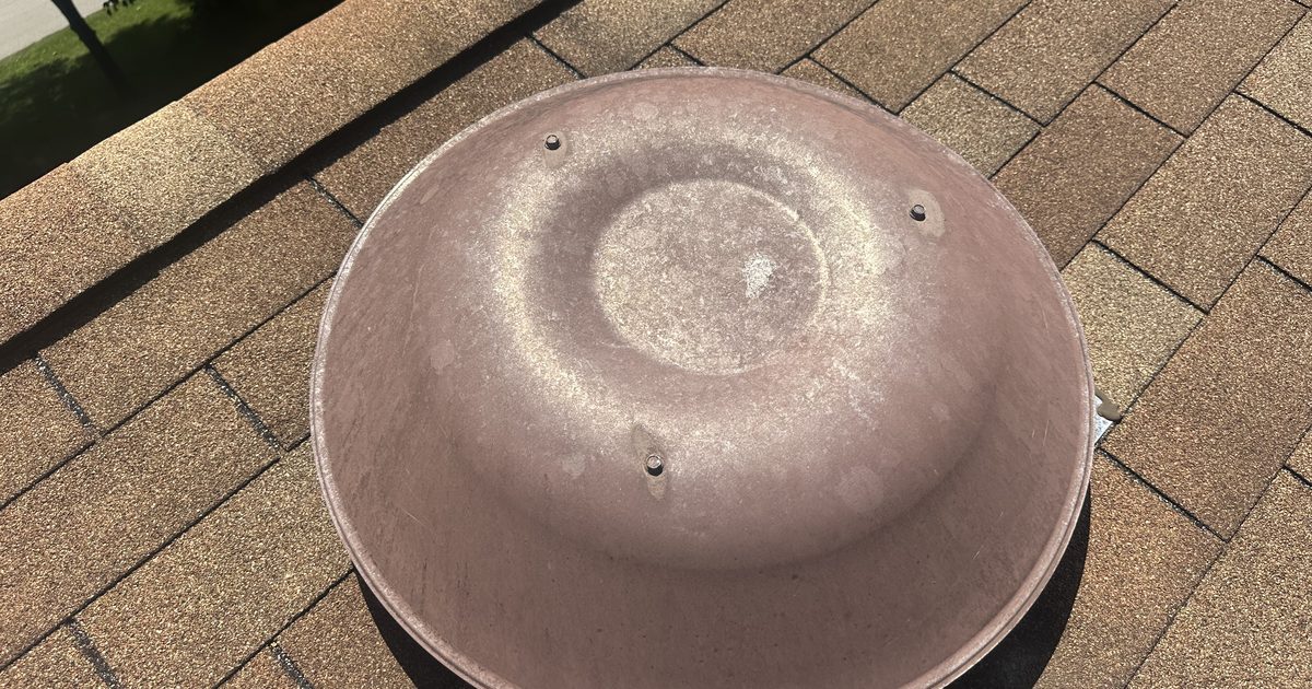 Hail-dented aluminum roof vent cap, the kind of impact evidence an insurance adjuster documents on a storm damage claim