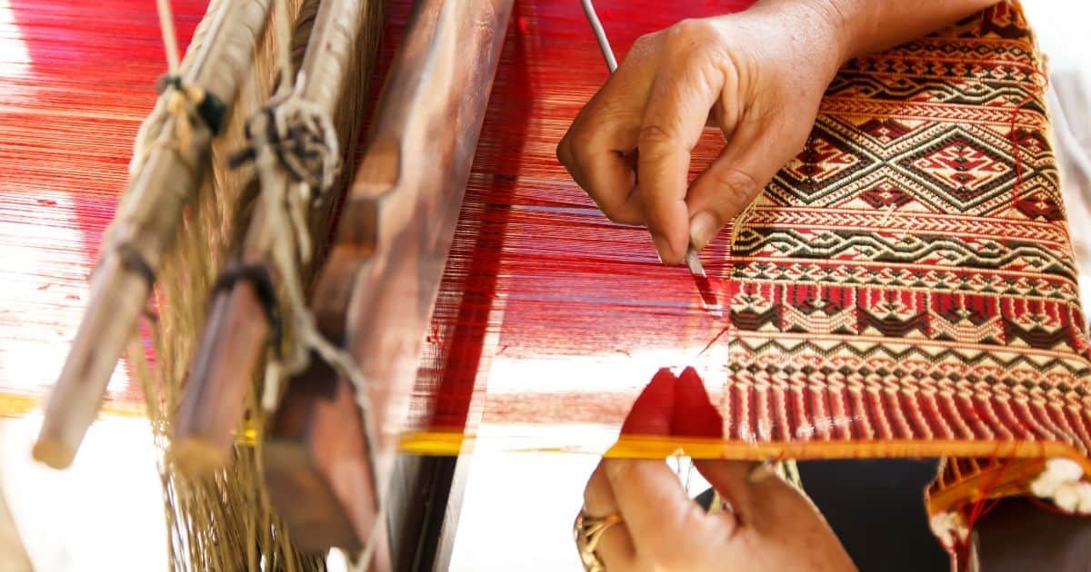 person weaving on a loom in one of the best oaxaca art towns in mexico