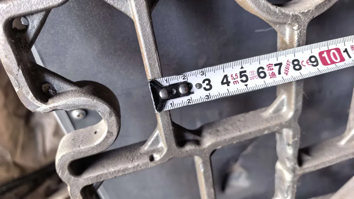 Close view of a cast grid separator measured with a tape