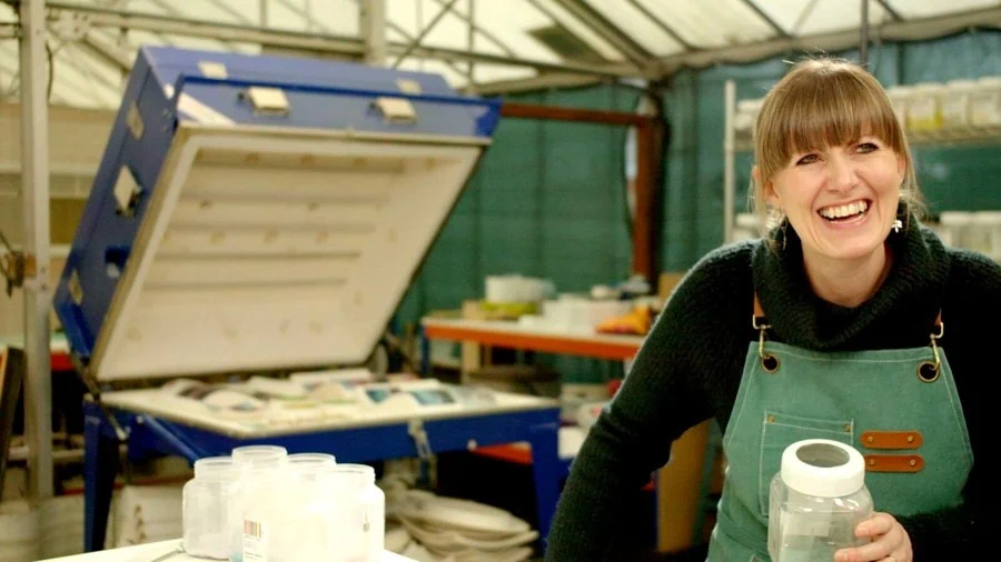 A glassmaker laughing in her studio, from People Make Wigan