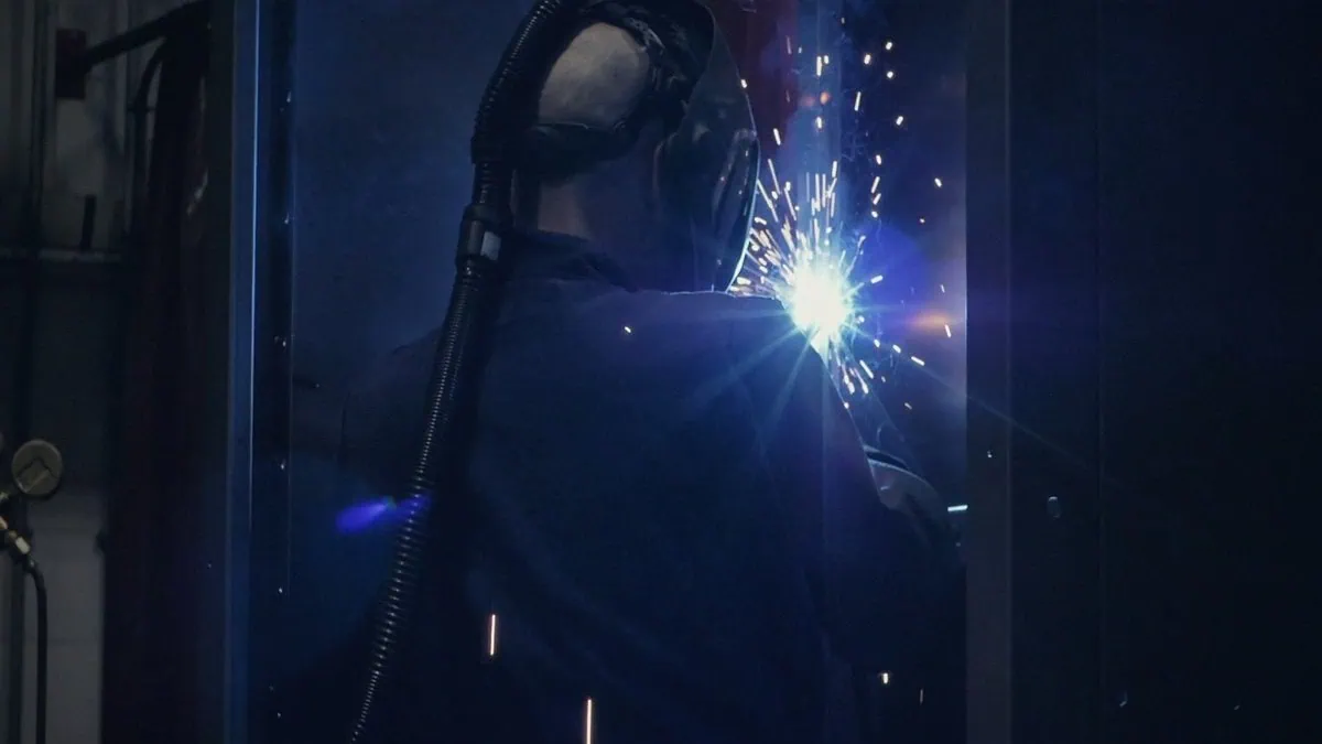 A welder at work behind a screen of sparks at Anord Mardix