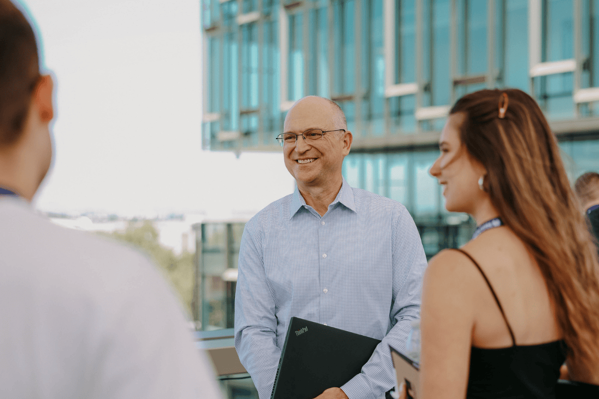 The picture shows two men and a woman talking to each other.