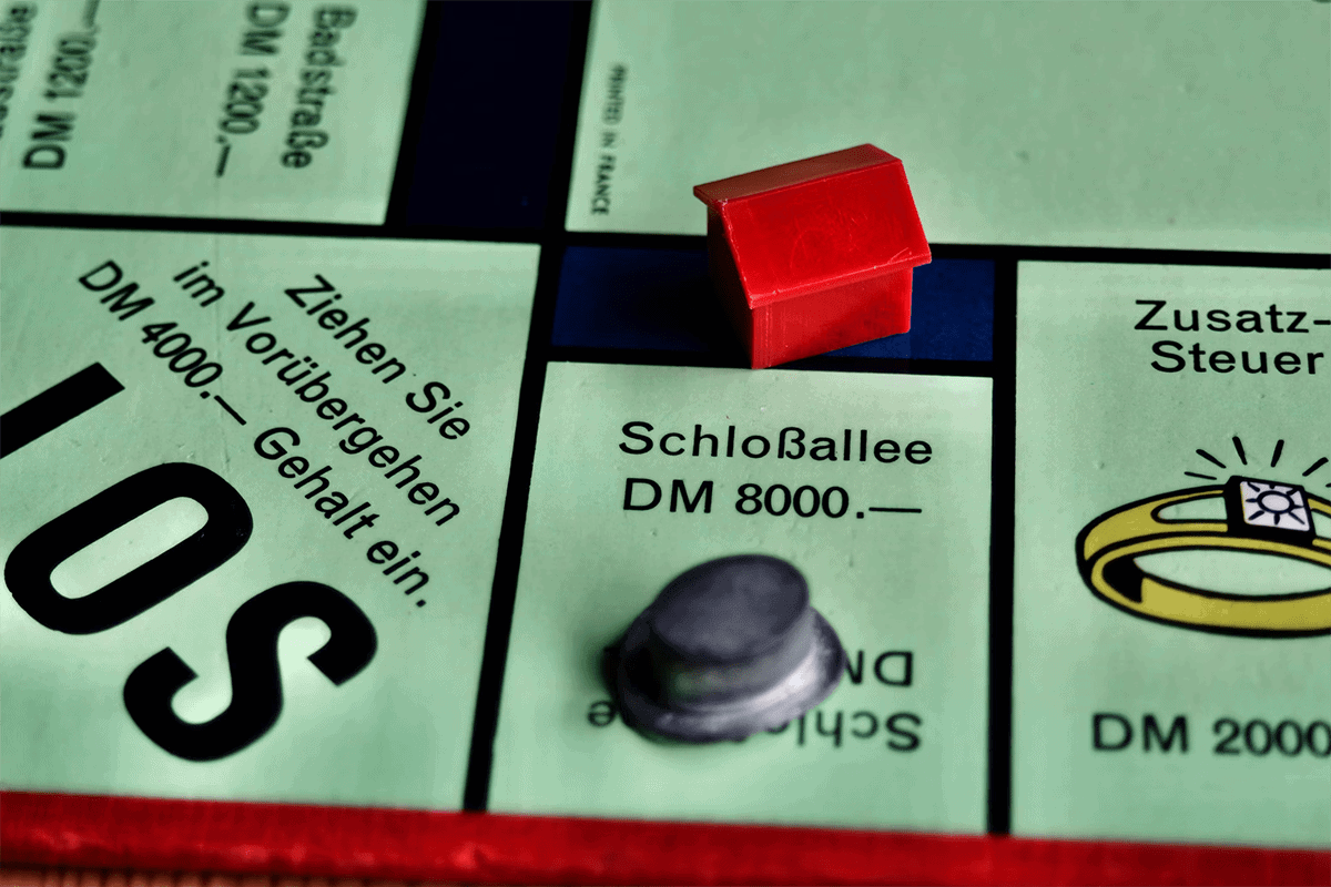 Ausschnitt eines deutschen Monopoly-Spiels mit Haus auf der Schlossallee.