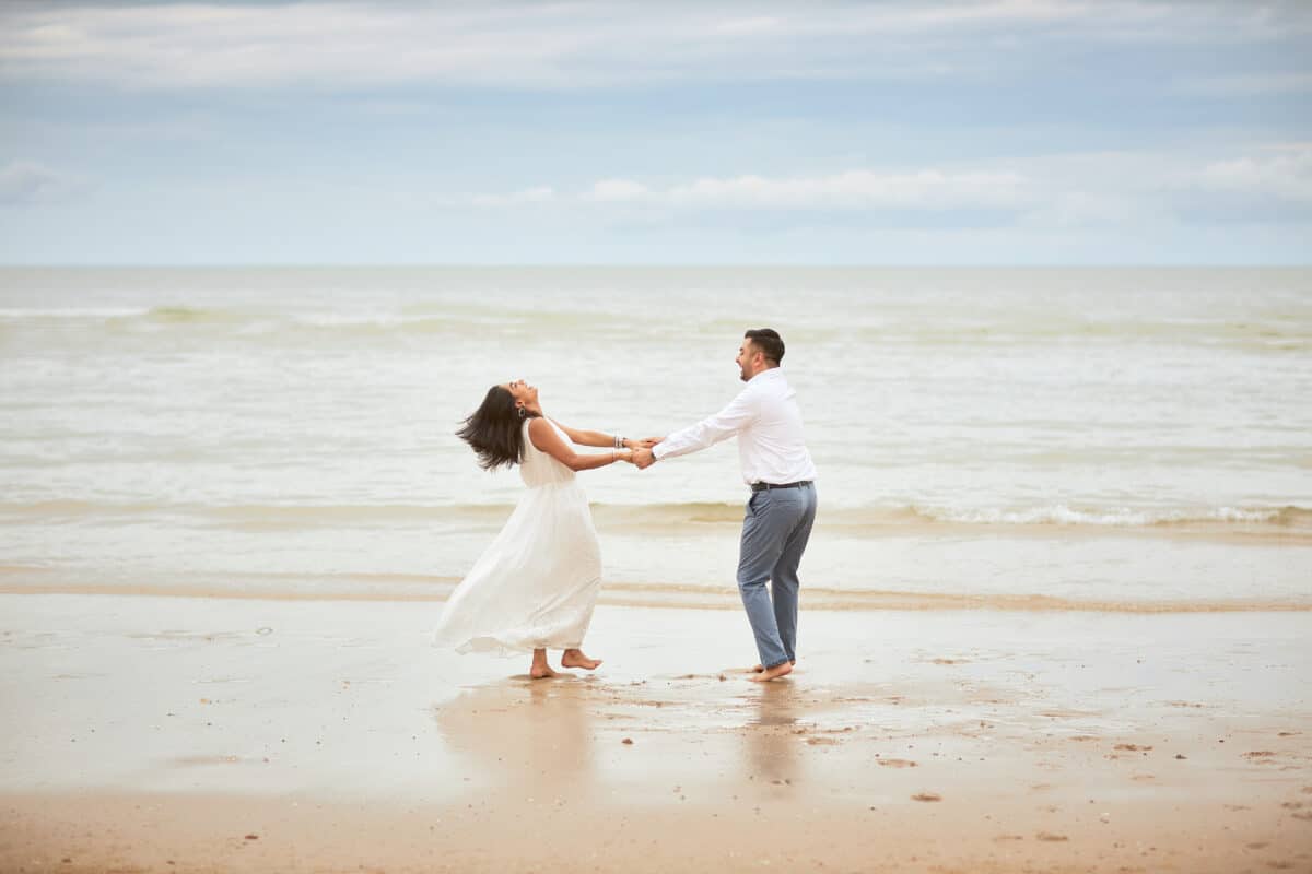 Couple holding hands in the surf during a Hua Hin pre-wedding photoshoot