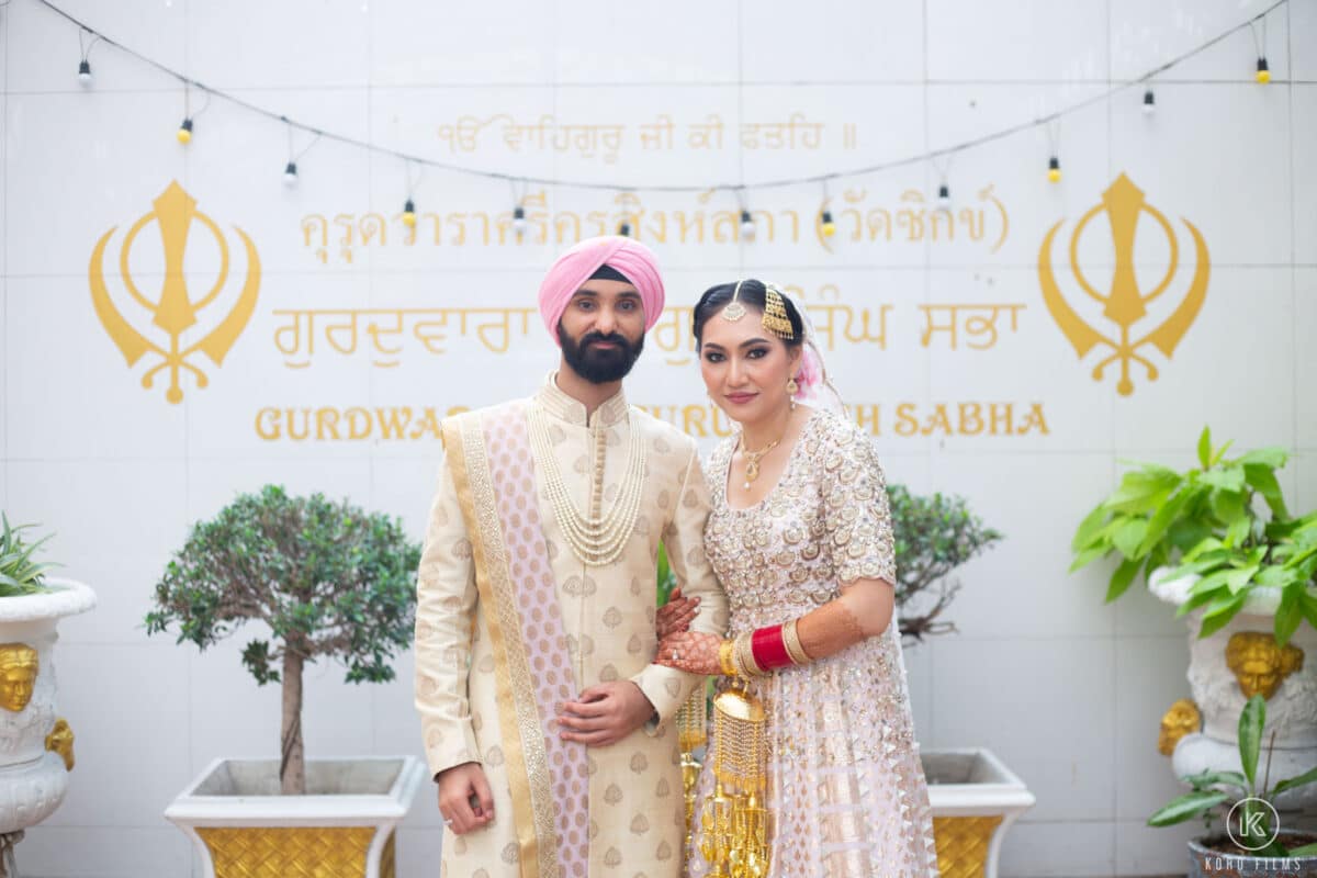 Sikh bride and groom at the entrance of Gurdwara Sri Guru Singh Sabha in Bangkok