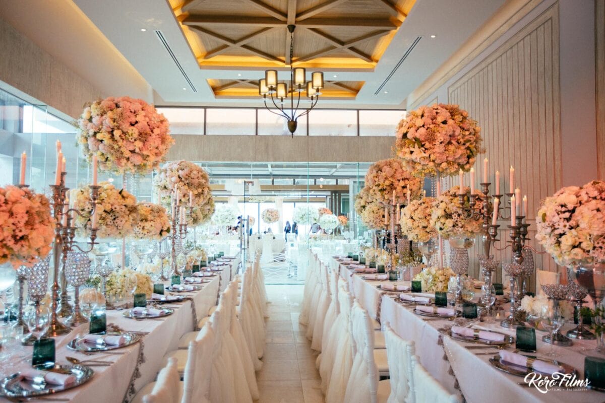 Long wedding tables with peach and white flowers and silver candelabras in Hua Hin