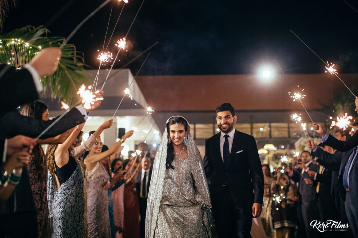 Guests hold sparklers as the bride and groom walk through at their Walima in Hua Hin