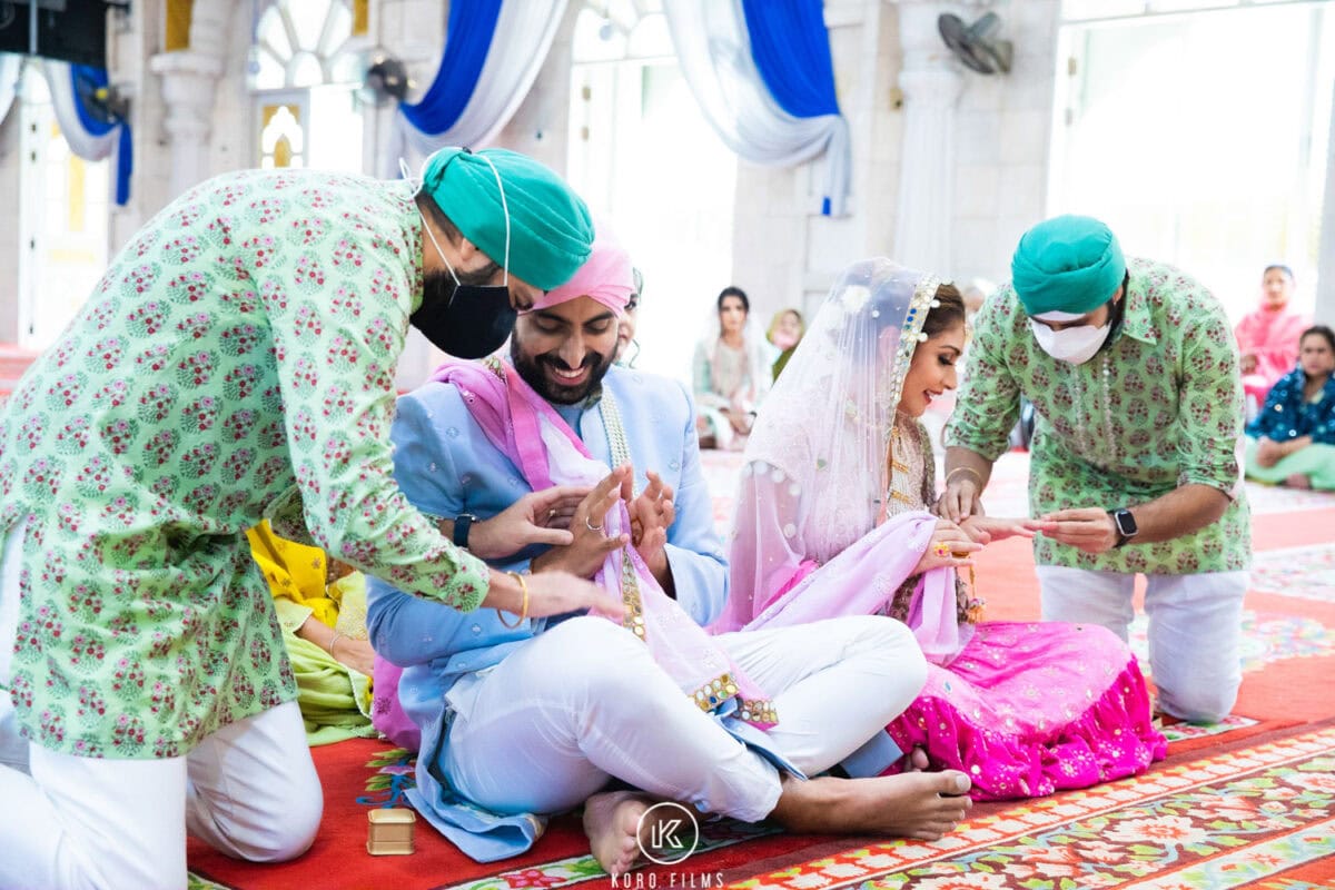Family members give shagun to the couple after the Anand Karaj