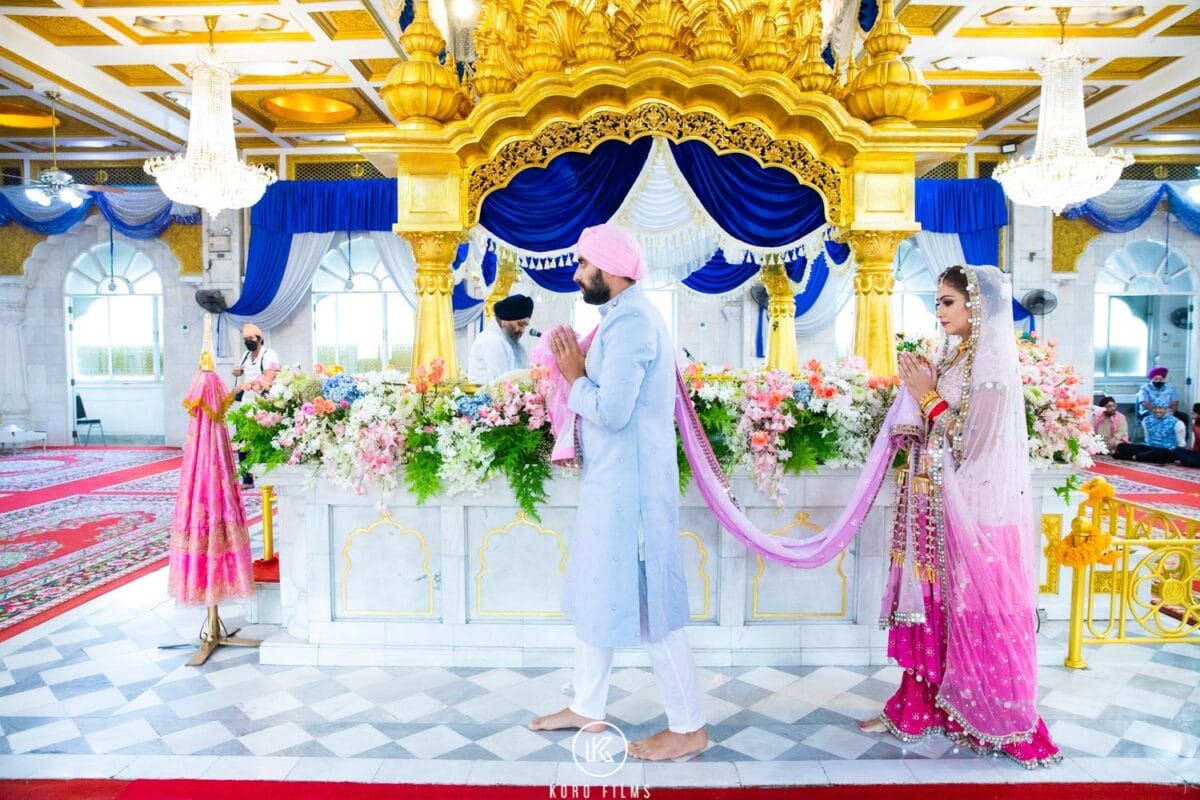 Groom leads the bride around Guru Granth Sahib Ji during the Laavan at Gurdwara Sri Guru Singh Sabha, Bangkok