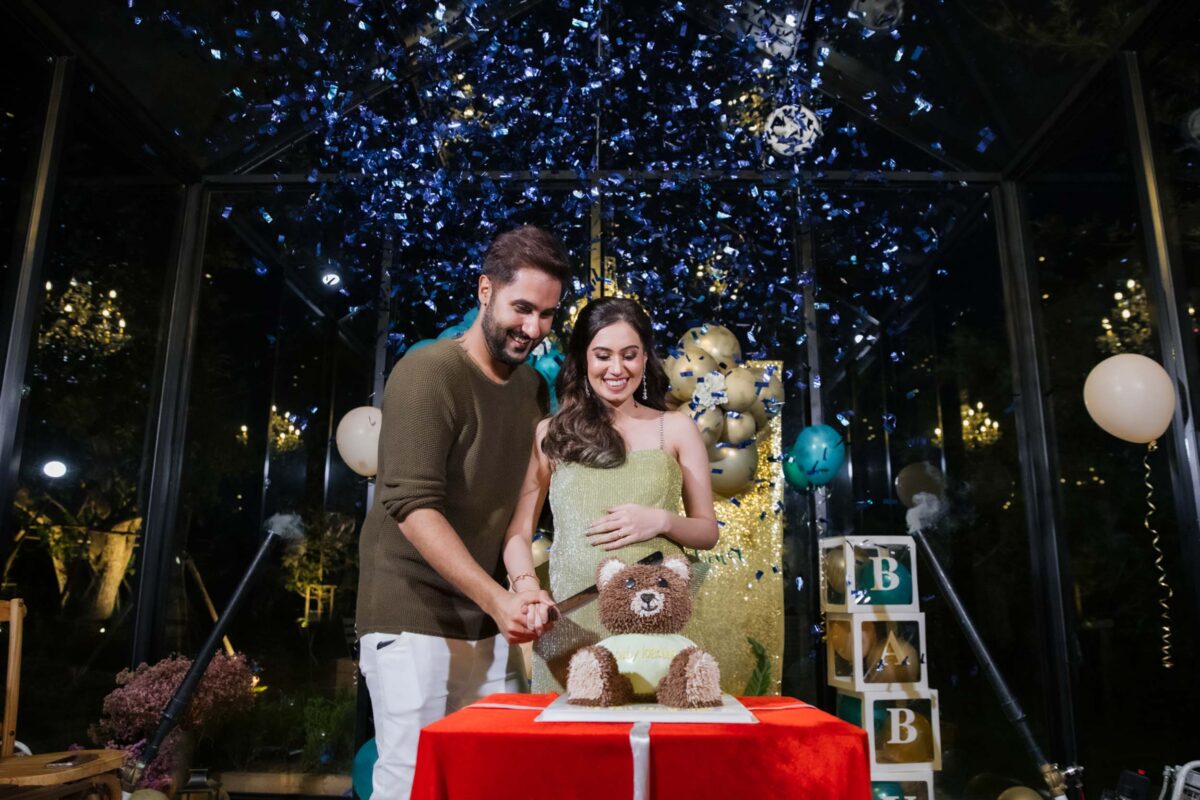 Nikki and her partner at the cake table at her baby shower in Bangkok