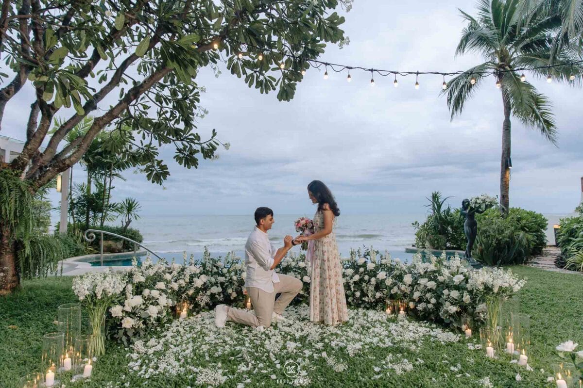 Vatsal kneels to propose to Paridhi inside a heart of white flowers on the seafront lawn of La Residence Villa, InterContinental Hua Hin