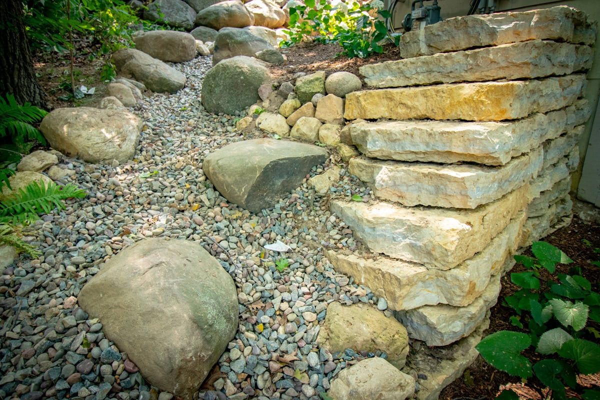 big stones and pebbles by stone wall