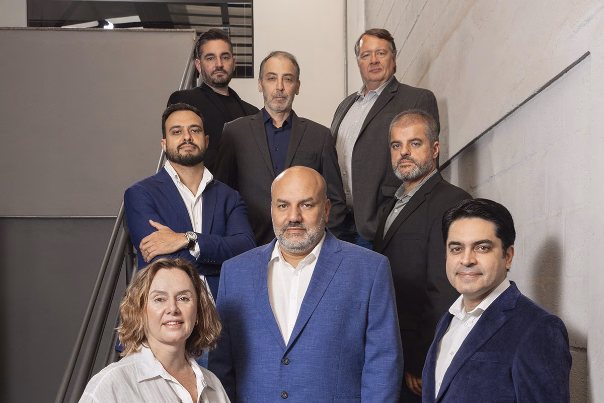Diretoria e gerência da Rysax do Brasil reunidas na escada da sede