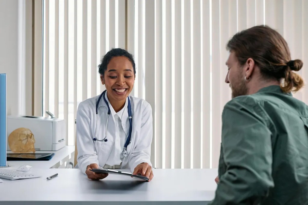 Man consulting a doctor after a pilonidal cyst bursts