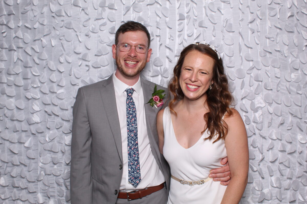 wedding couple poses for a picture in their wedding photo booth
