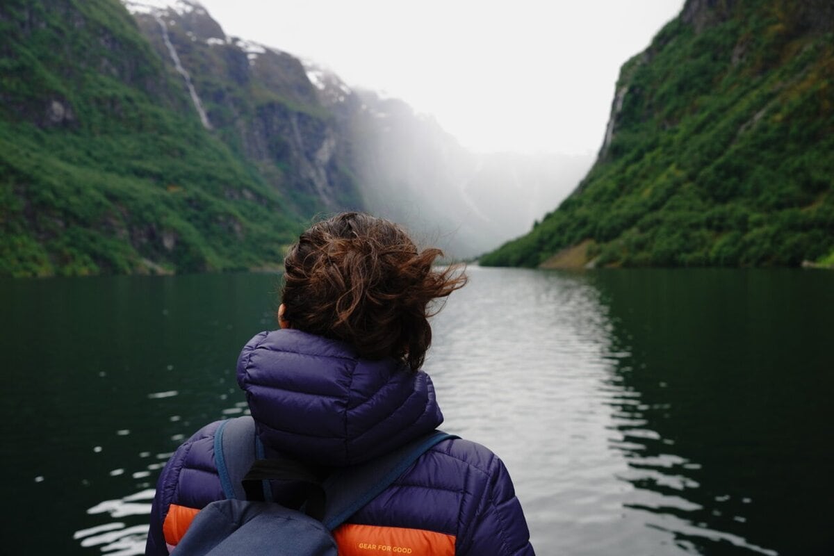 woman looking at the landscape with a storm approaching during a fjord cruise from flam to gudvangen, Norway