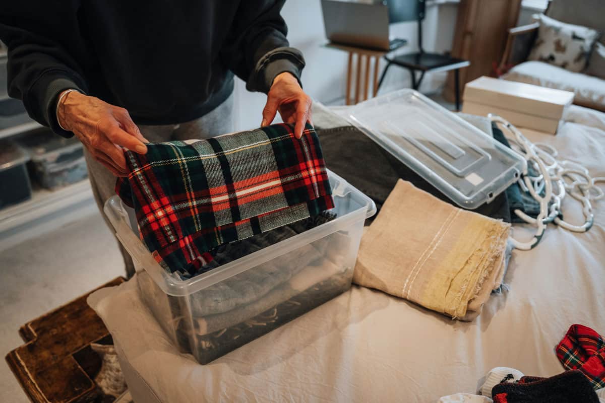 Person decluttering a room for seasonal storage