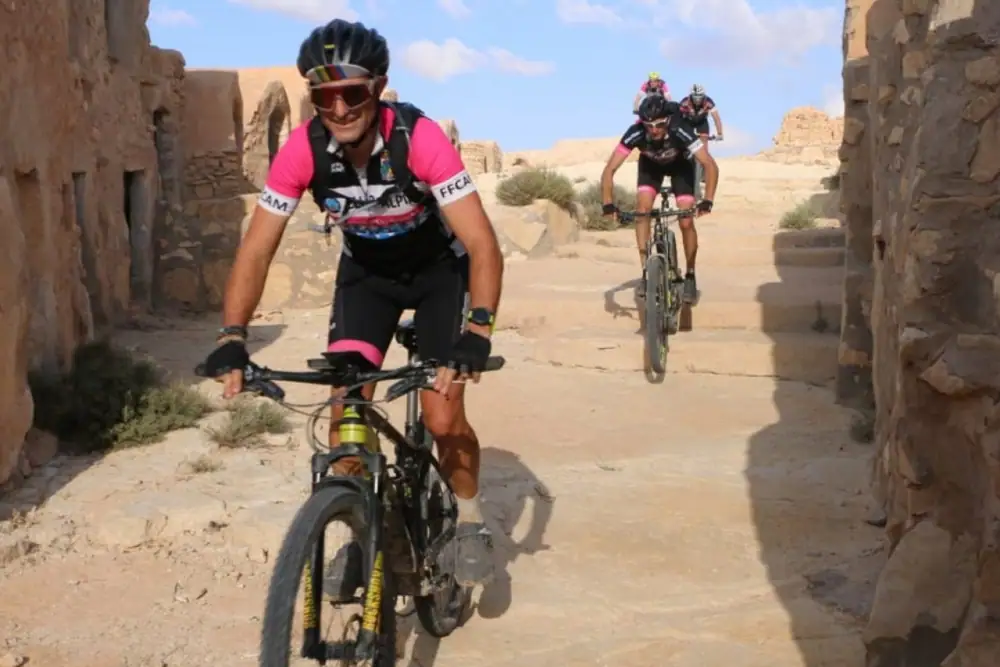 Cyclists riding through the Dahar mountain range during a Tunisia bike tour