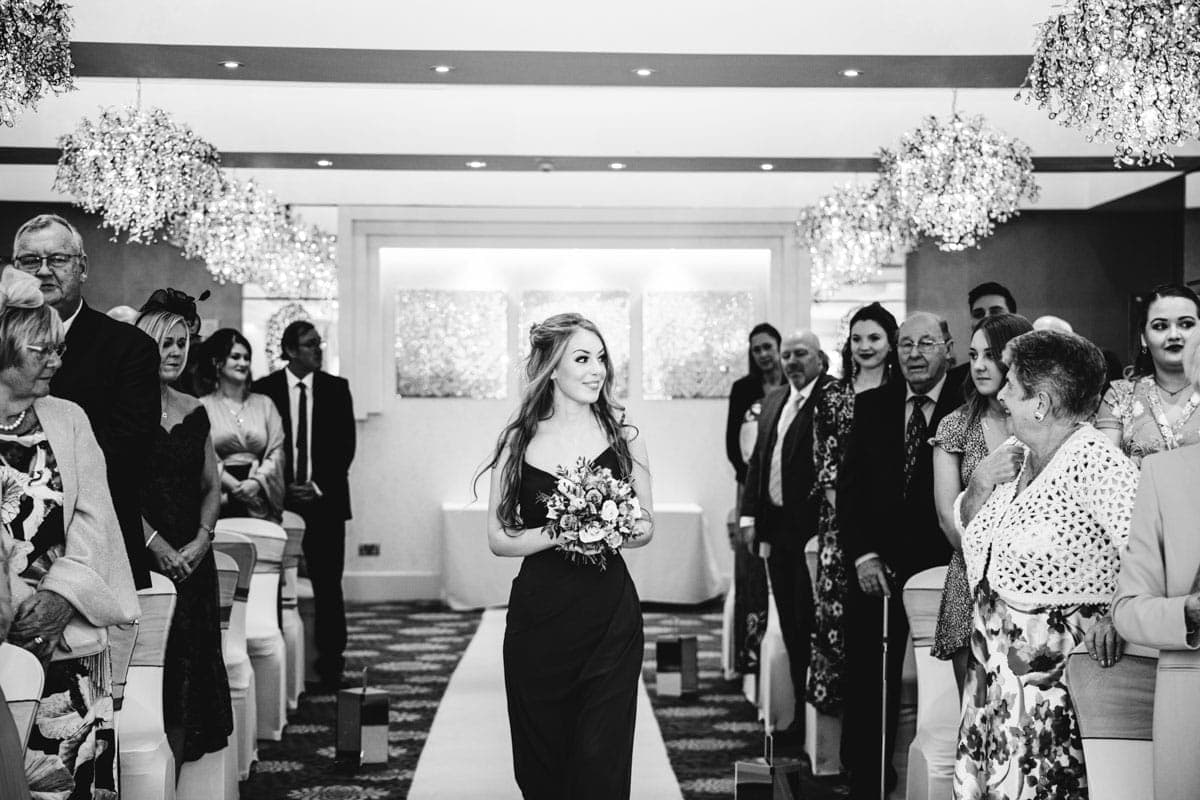 bridesmaid walking down the aisle at thornton hall hotel