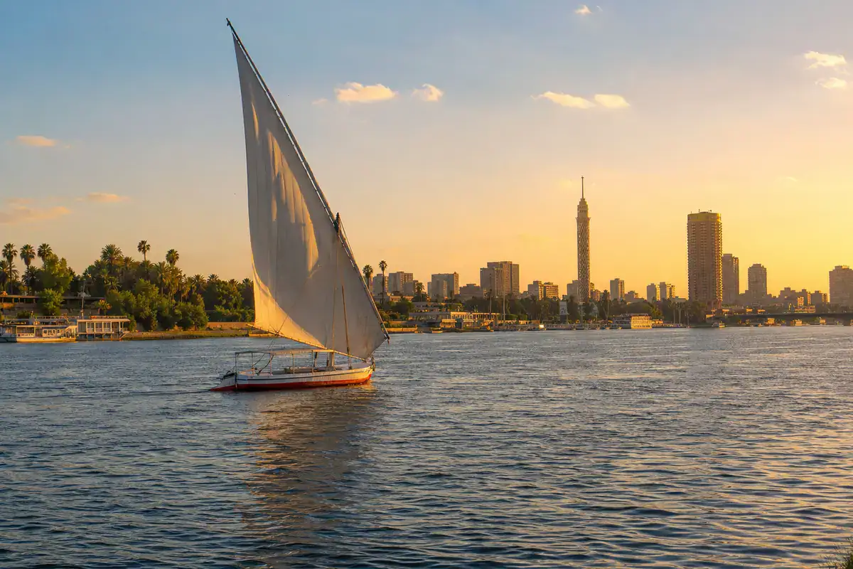 Traditional felucca sailing beside the city skyline