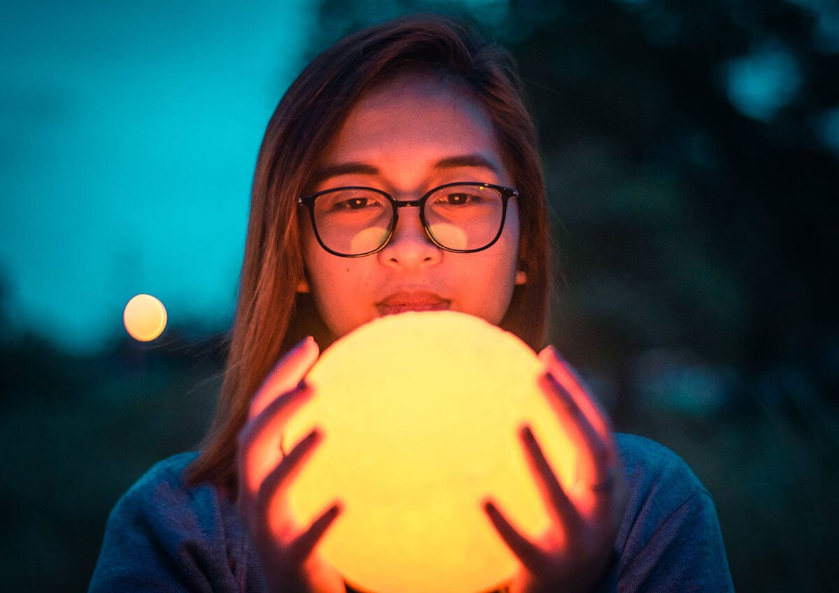 Woman holding a moon lamp in her hands