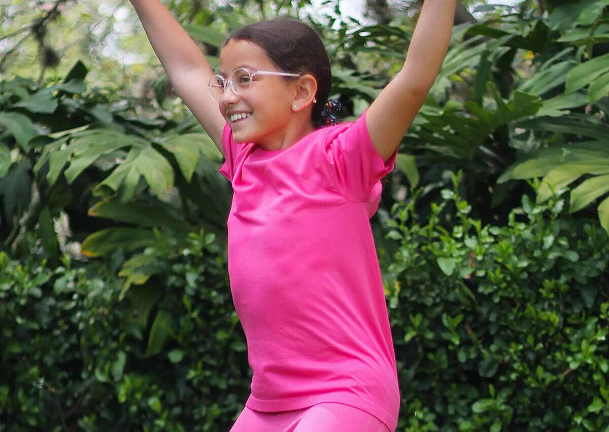niña con lentes luce una camiseta deportiva color fucsia
