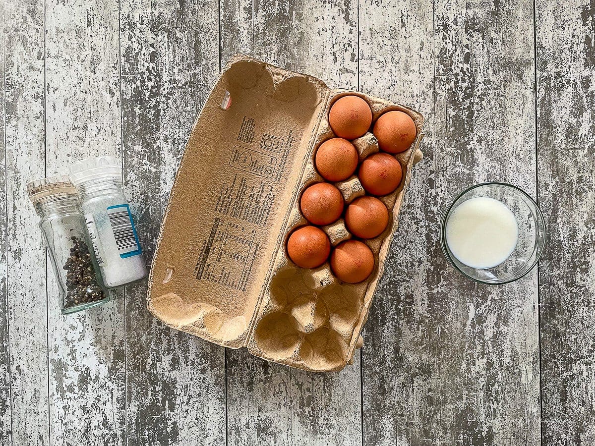 eggs, milk and salt and pepper on table.