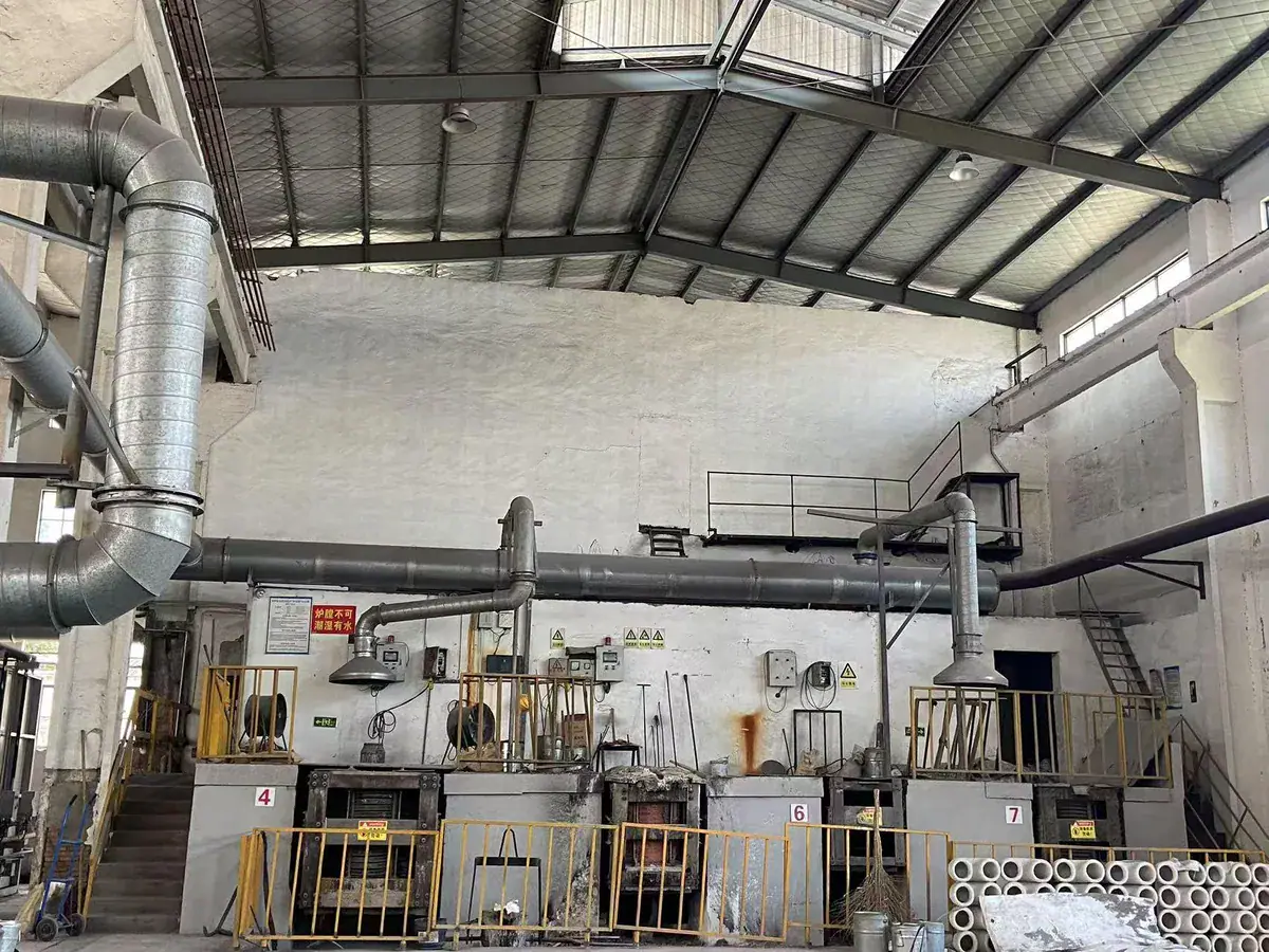 Foundry equipment beneath extraction ducts inside a production building