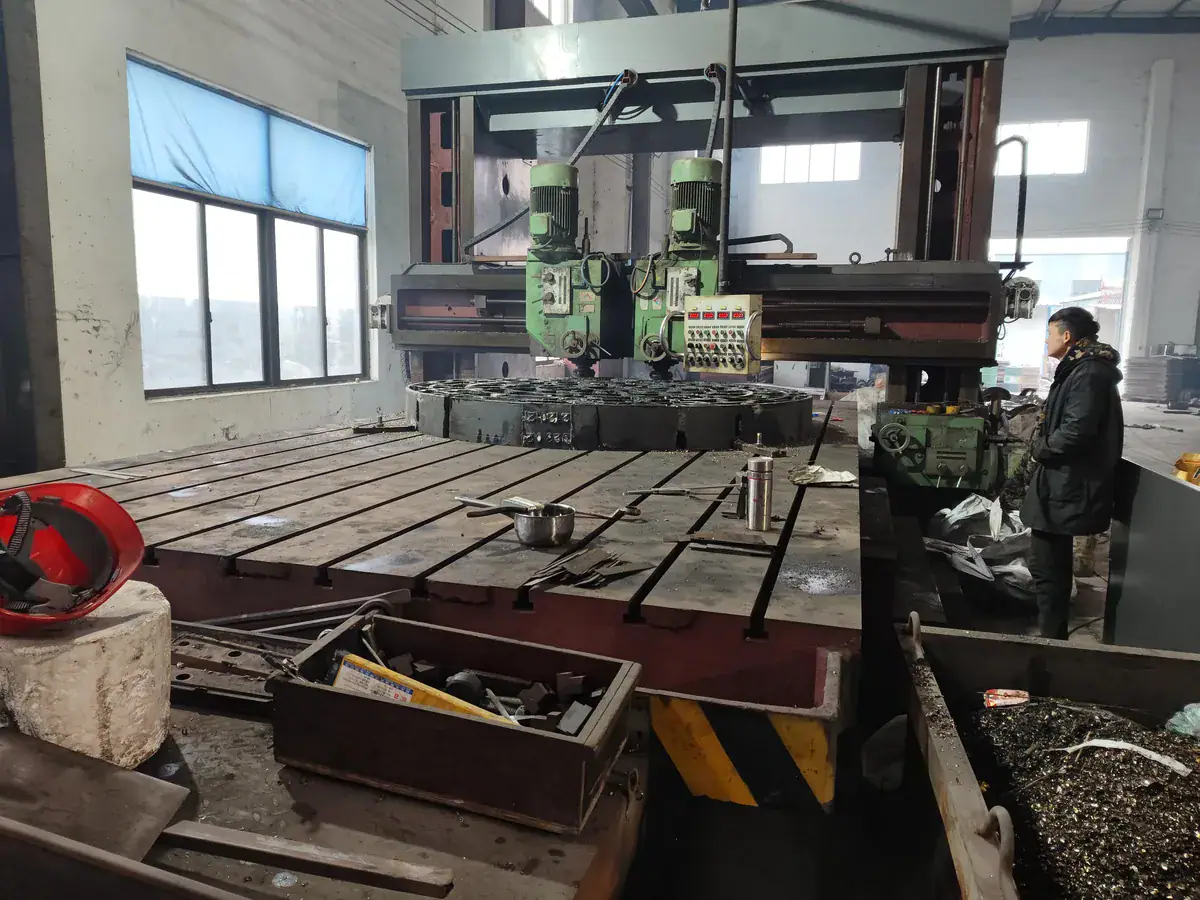 Large gantry-style machining equipment with an operator beside the work table
